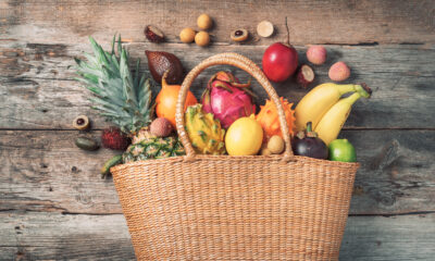 Tropical fruits in a basket on wooden background | https://fruitsauction.com/