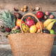 Tropical fruits in a basket on wooden background | https://fruitsauction.com/