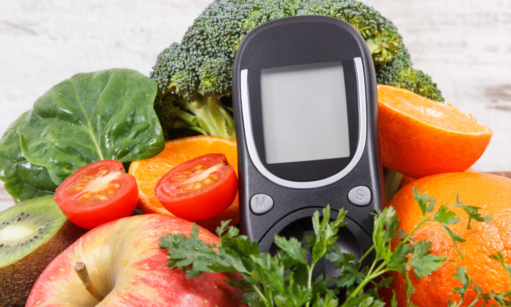 Glucometer for measuring sugar level with ripe natural fruits and vegetables. Concept of diabetes, healthy lifestyles and nutrition | https://fruitsauction.com/